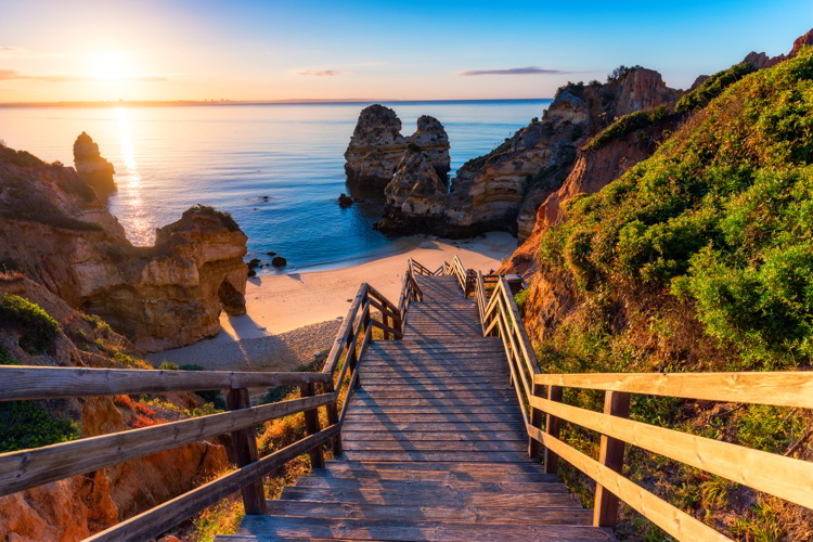 Wooden footbridge to the beach Praia do Camilo, Portugal.