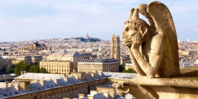 Stone gargoyle looking over the Paris rooftops