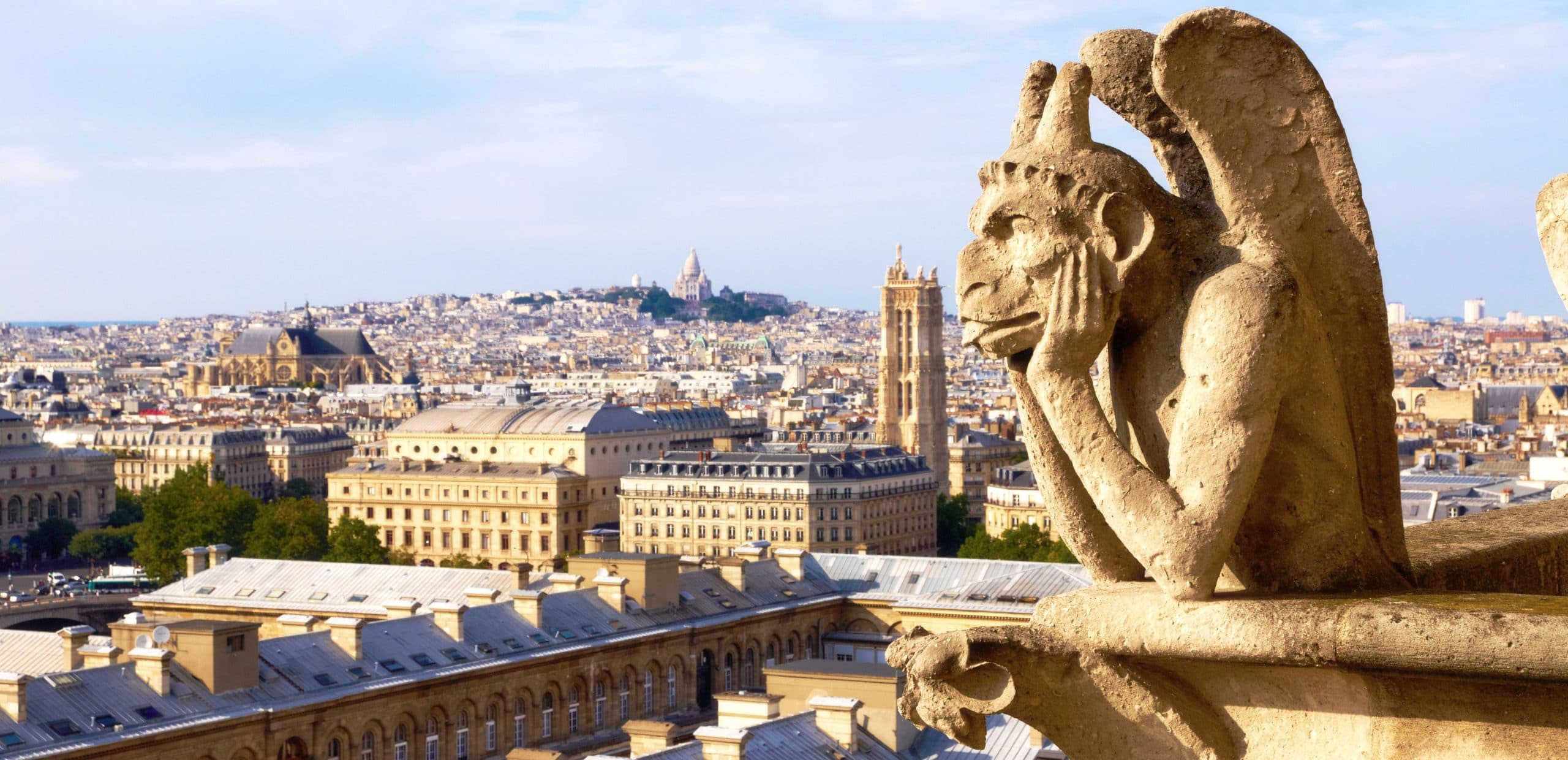 Stone gargoyle looking over the Paris rooftops