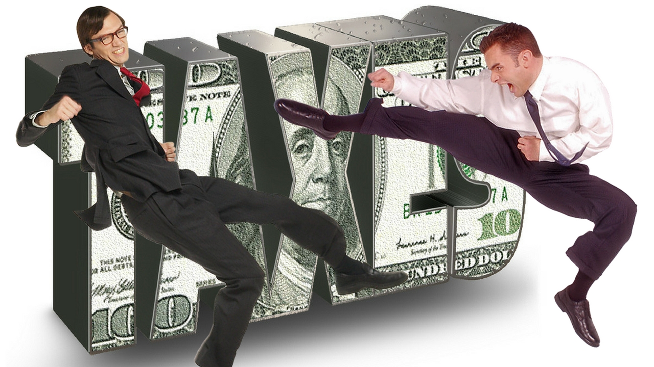 A guy karate kicking a man dressed up like an IRS agent with the word taxes in the background over a US$100 bill