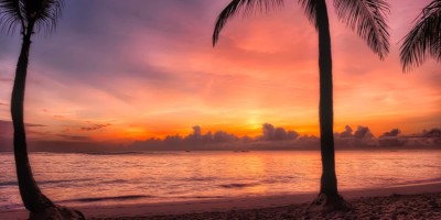 sunrise at dominican republic beach, the sun just above the horizon and the sky purple, pink and orange