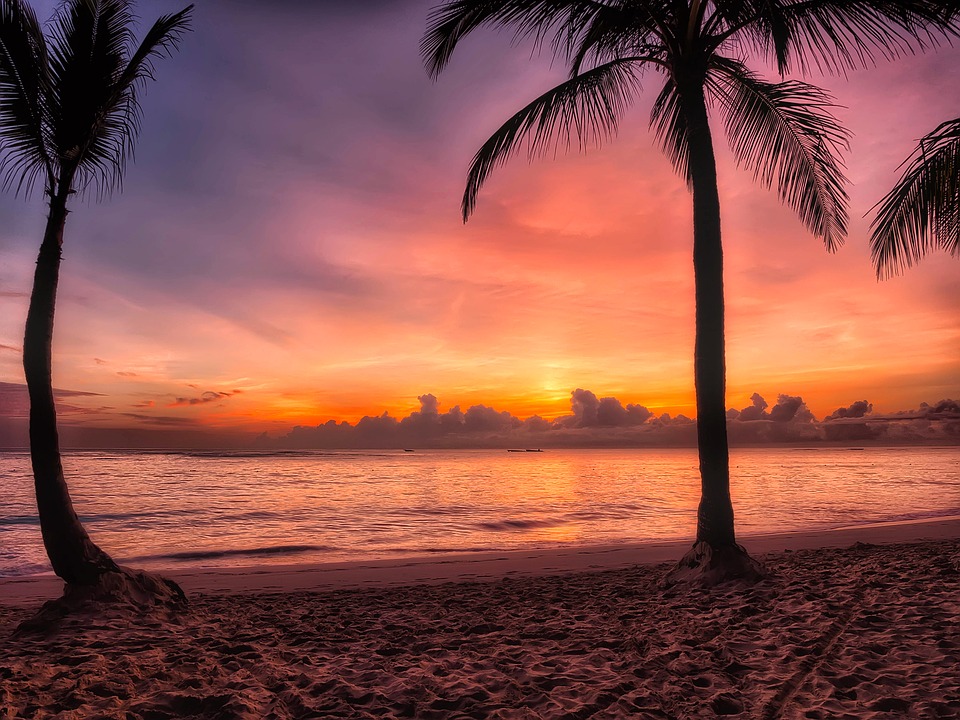 sunrise at dominican republic beach, the sun just above the horizon and the sky purple, pink and orange