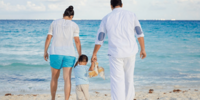 Prents hold thier child's hand at the beach