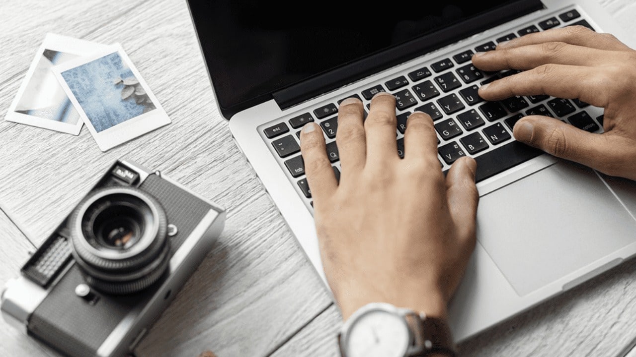 Person at a laptop with camera next to him