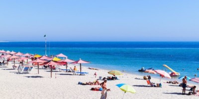 portugal bech with umbrellas and people enjoying the sun