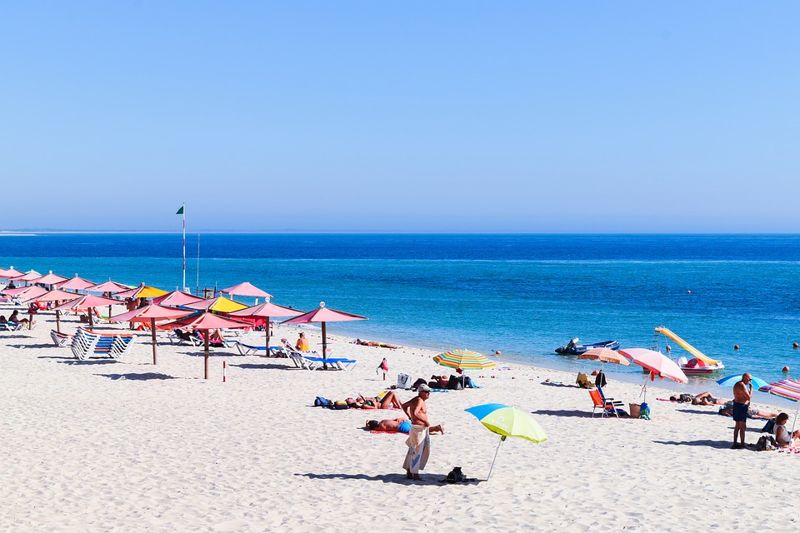 portugal bech with umbrellas and people enjoying the sun