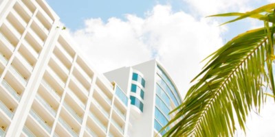 view of the westin playa bonita hotel in panama city, blue sky and a palm tree can be seen