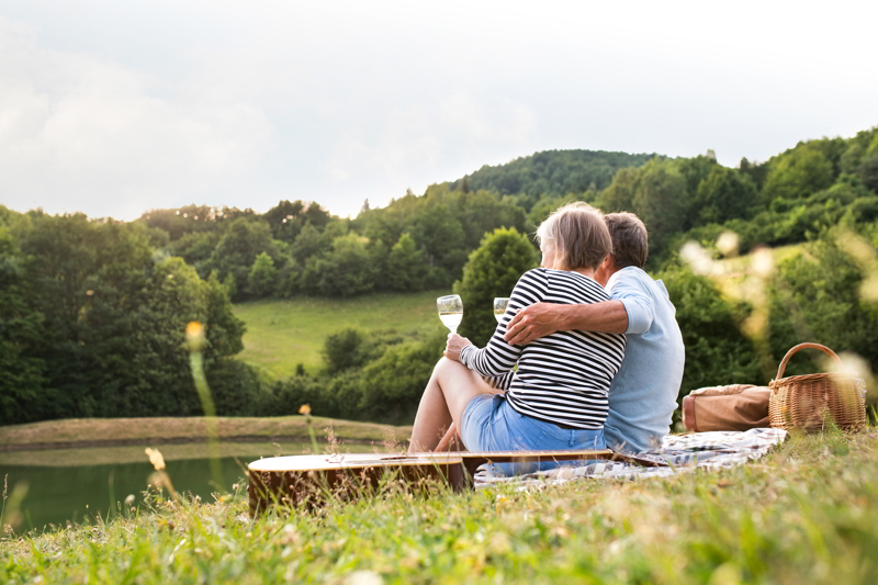 Senior couple at the lake having a picnic.