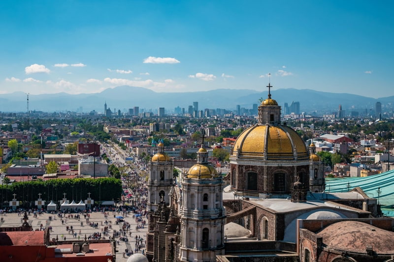 Mexico City, Mexico, Basilica of Our Lady of Guadalupe with Mexico City skyline in the background.