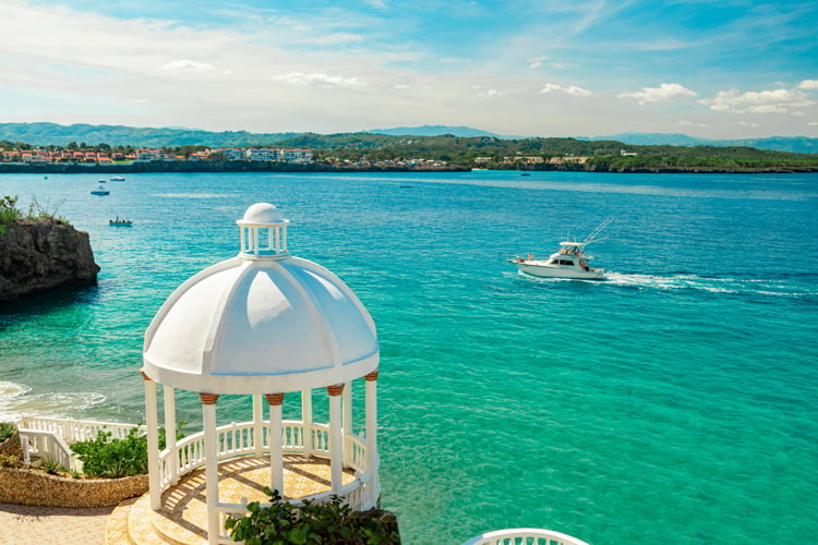 Beautiful white gazebo and tropical flower garden on Caribbean ocean background, summer mountain view in Sosua, Puerto Plata, Dominican Republic