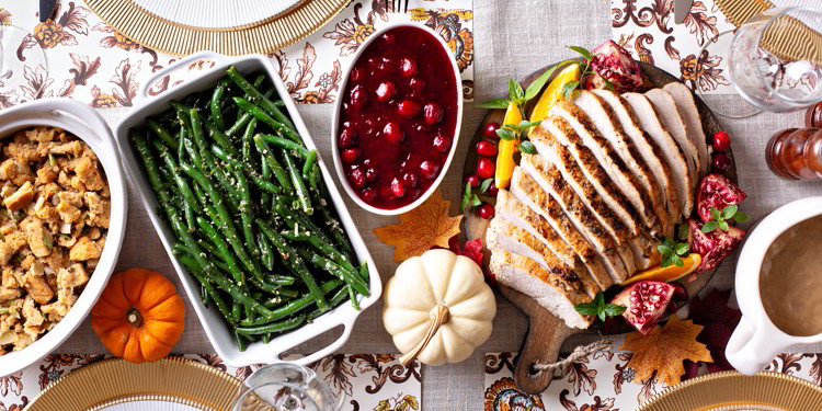 Thanksgiving dinner table with sliced turkey and sides, overhead shot