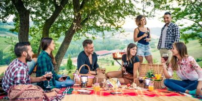 Happy friends doing barbecue outdoors