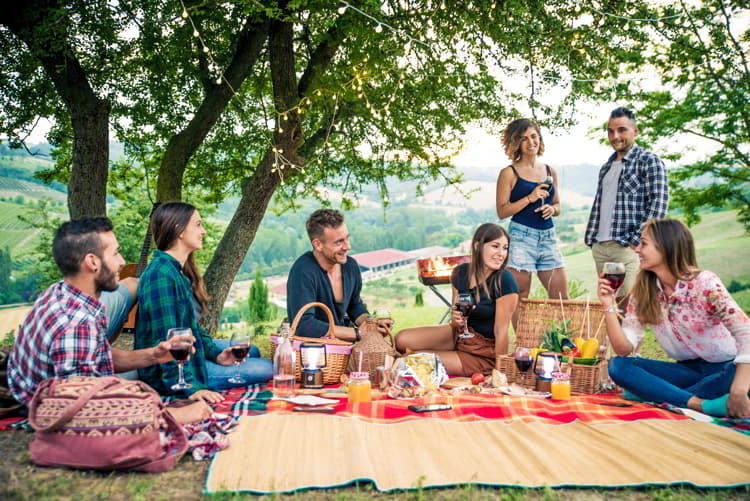 Happy friends doing barbecue outdoors