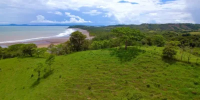 Green meadow with amazing view of tropical beach by the Pacific Ocean.