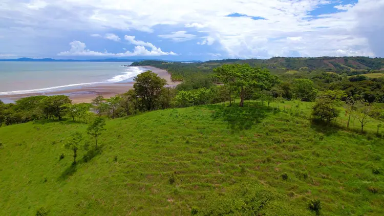 Green meadow with amazing view of tropical beach by the Pacific Ocean.