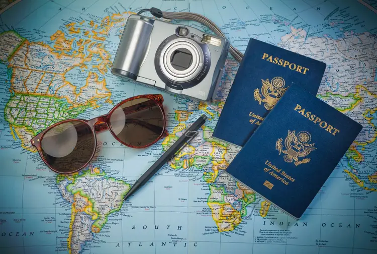 world map, camara, sunglasses and two american passports